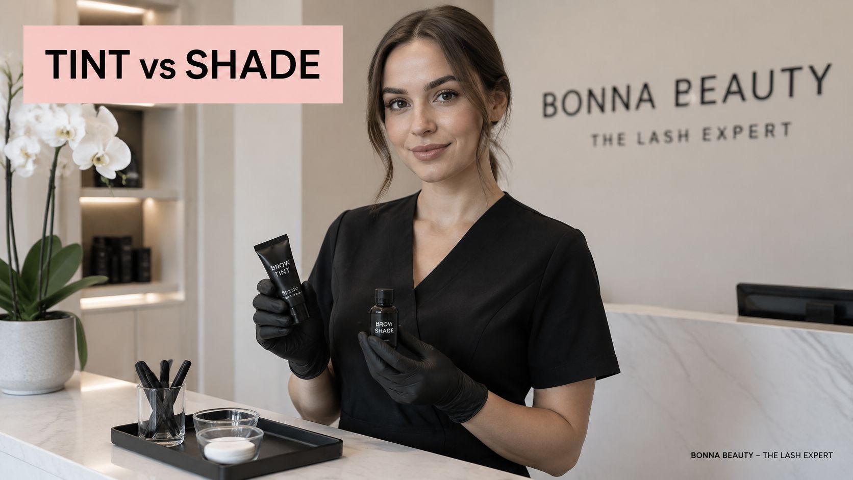 A professional beauty therapist in a salon holding brow tint and shade products for eyebrow services.