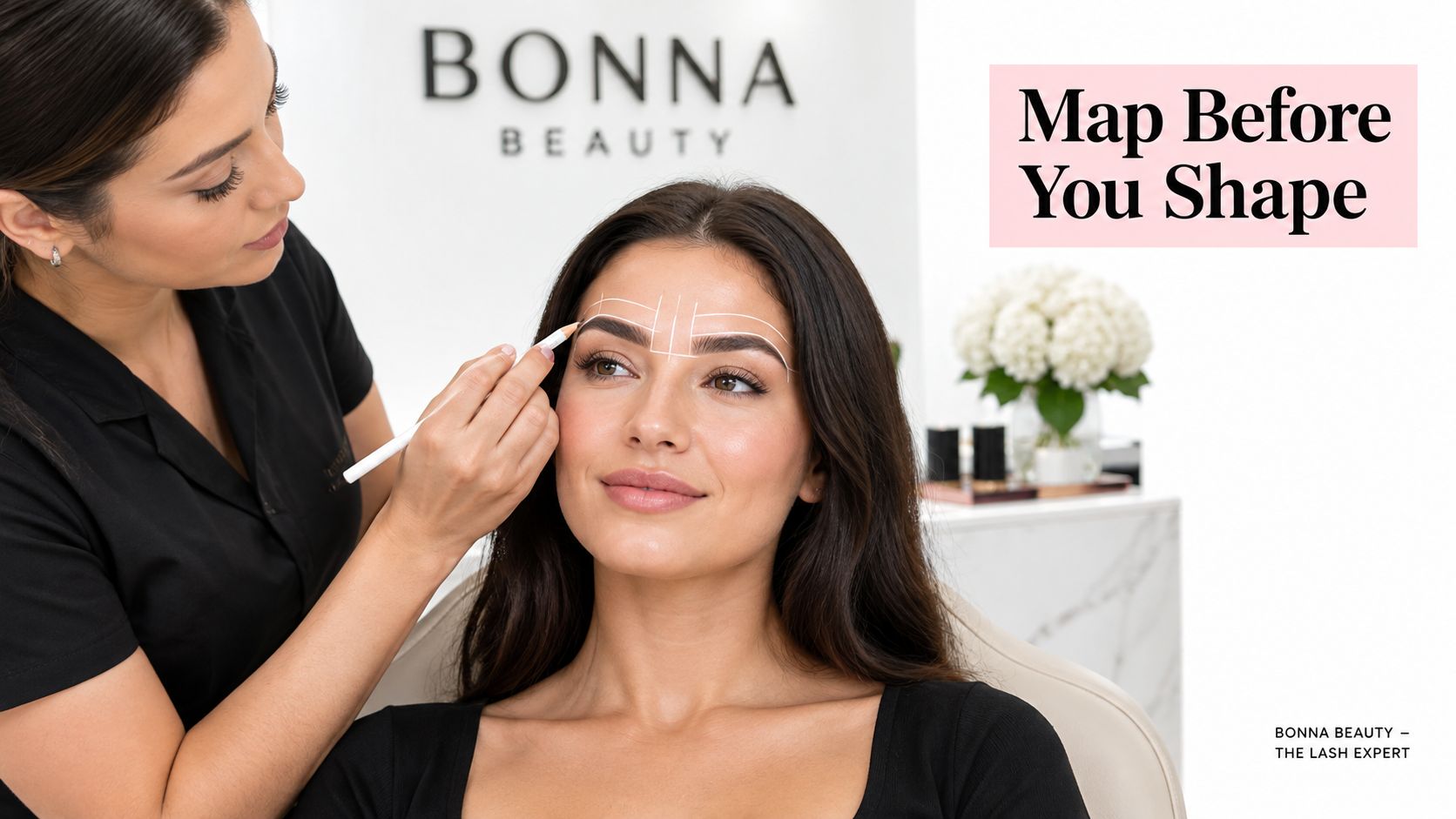 A professional beauty expert mapping eyebrows with a white pencil on a client before the shaping process.