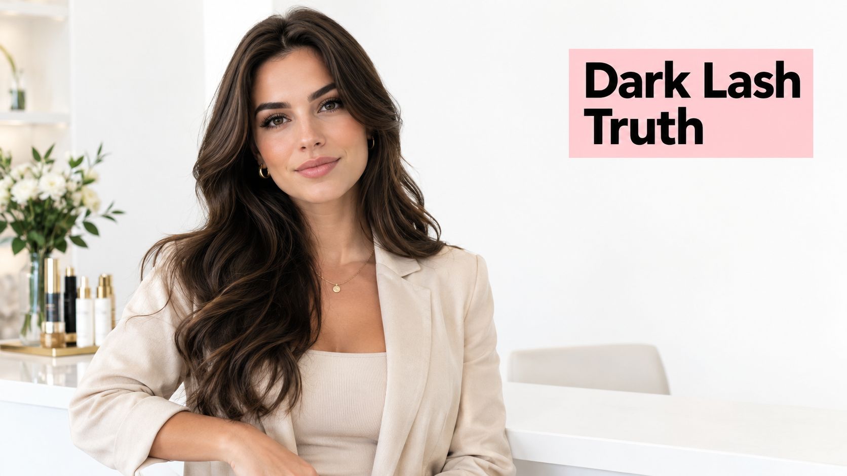 Lash Tint for Dark Lashes: What Actually Changes 10 A professional woman with long wavy brown hair posing in a clean, modern aesthetic beauty clinic.